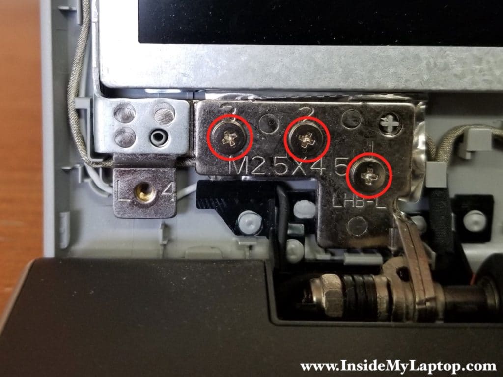 Three screws securing display hinges