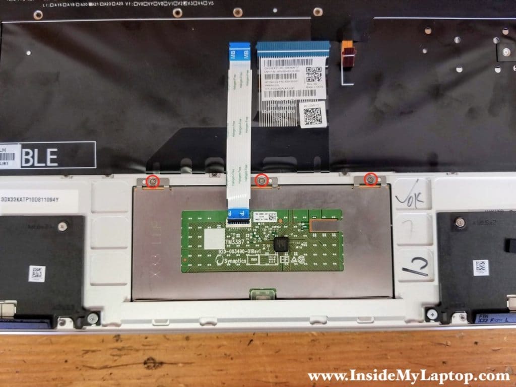Remove three screws attaching the trackpad to the palmrest.