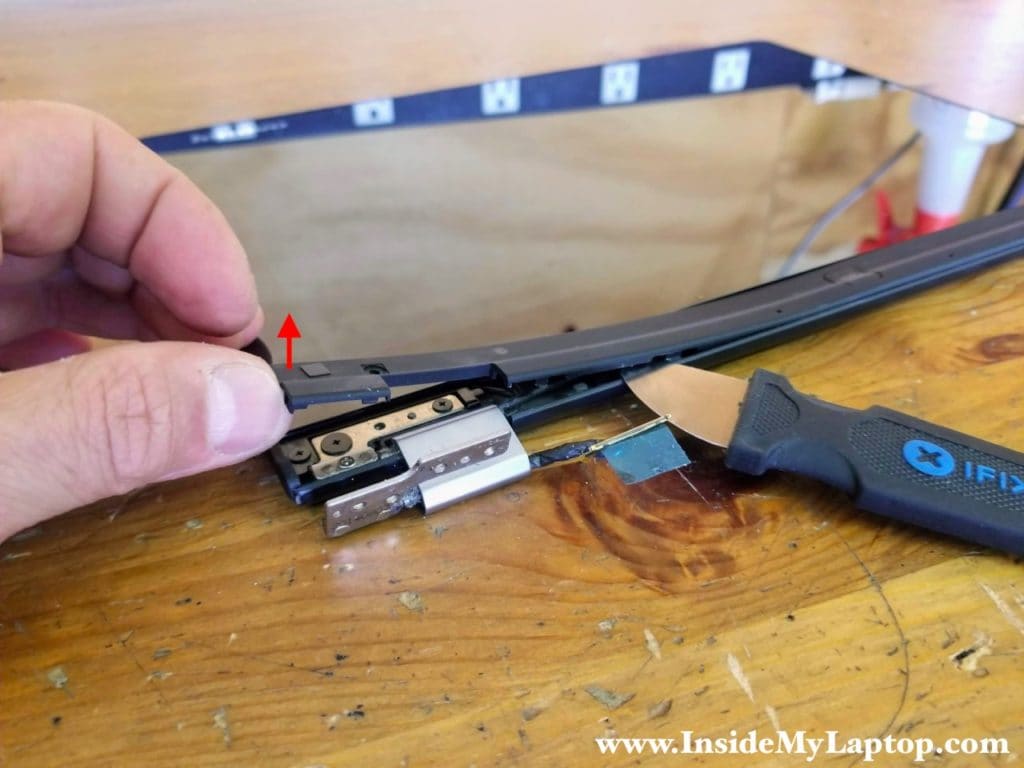 Start separating the hinge cover from the display panel.