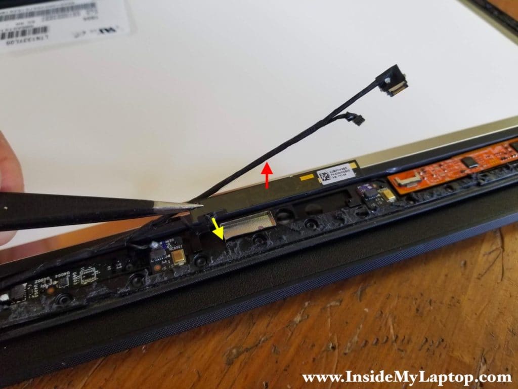 Carefully separate the webcam from the display assembly and disconnect the cable (yellow arrow).