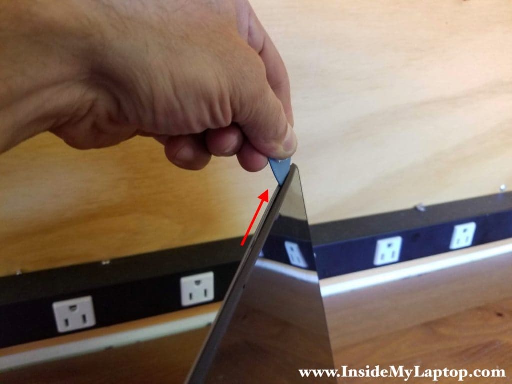 Moving the case opener tool along the side of the screen will help you to cut the adhesive tape.