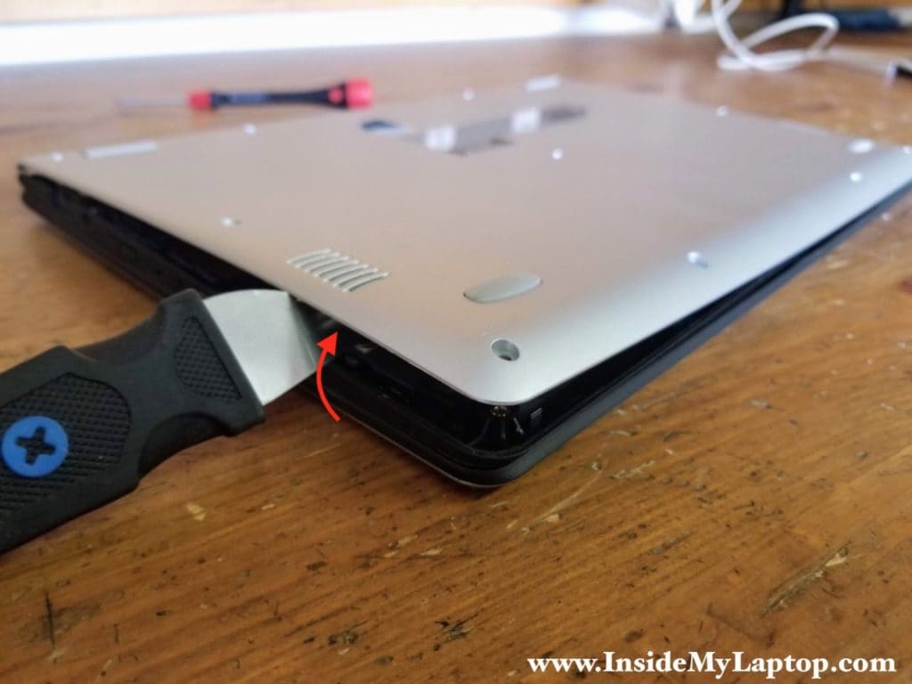 Carefully separate the bottom cover from the rest of the laptop.