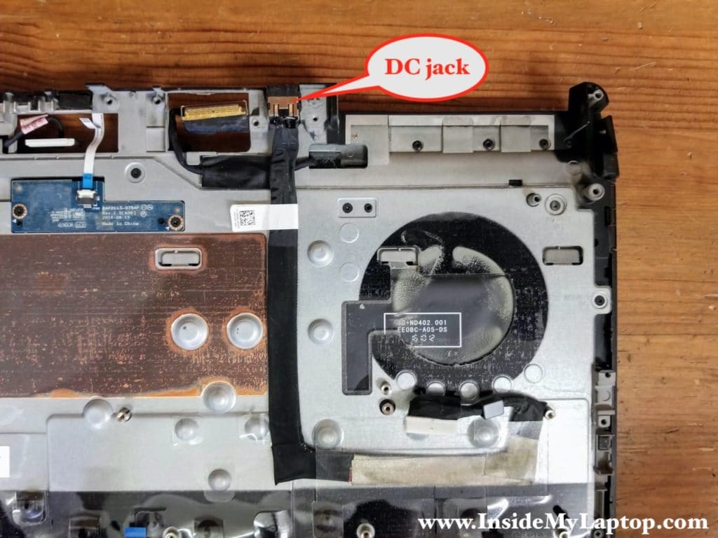 The DC power jack harness is taped to the palmrest assembly.