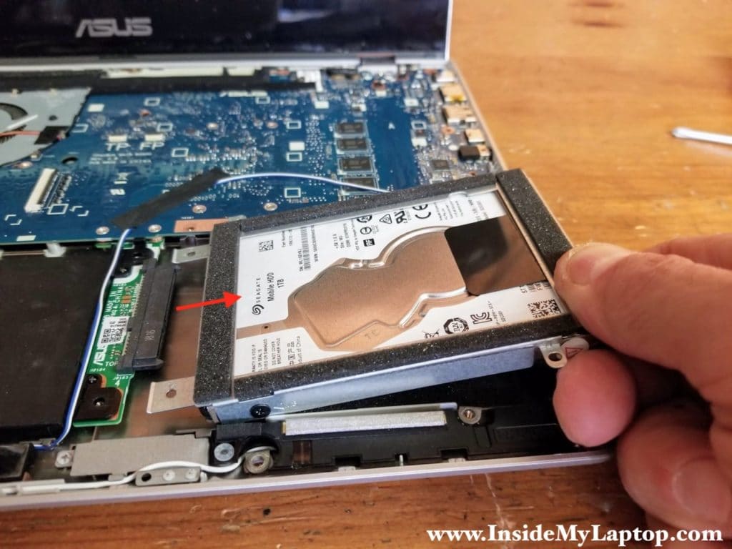 Lift up the right side of the hard drive assembly and pull it to the right to disconnect from the SATA connector board.