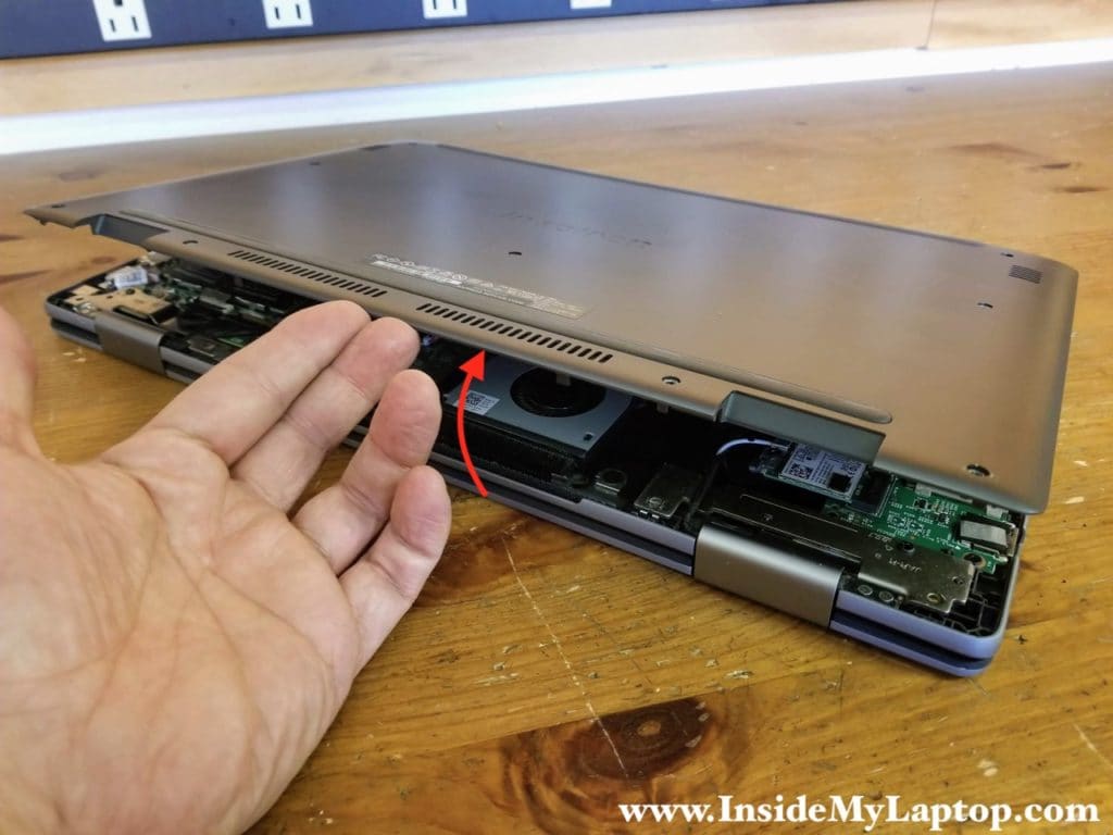 Start separating the base cover from the top case assembly on the rear side of the laptop.