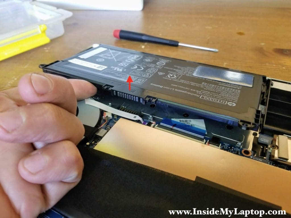 Lift up the battery to disconnect it from the motherboard.