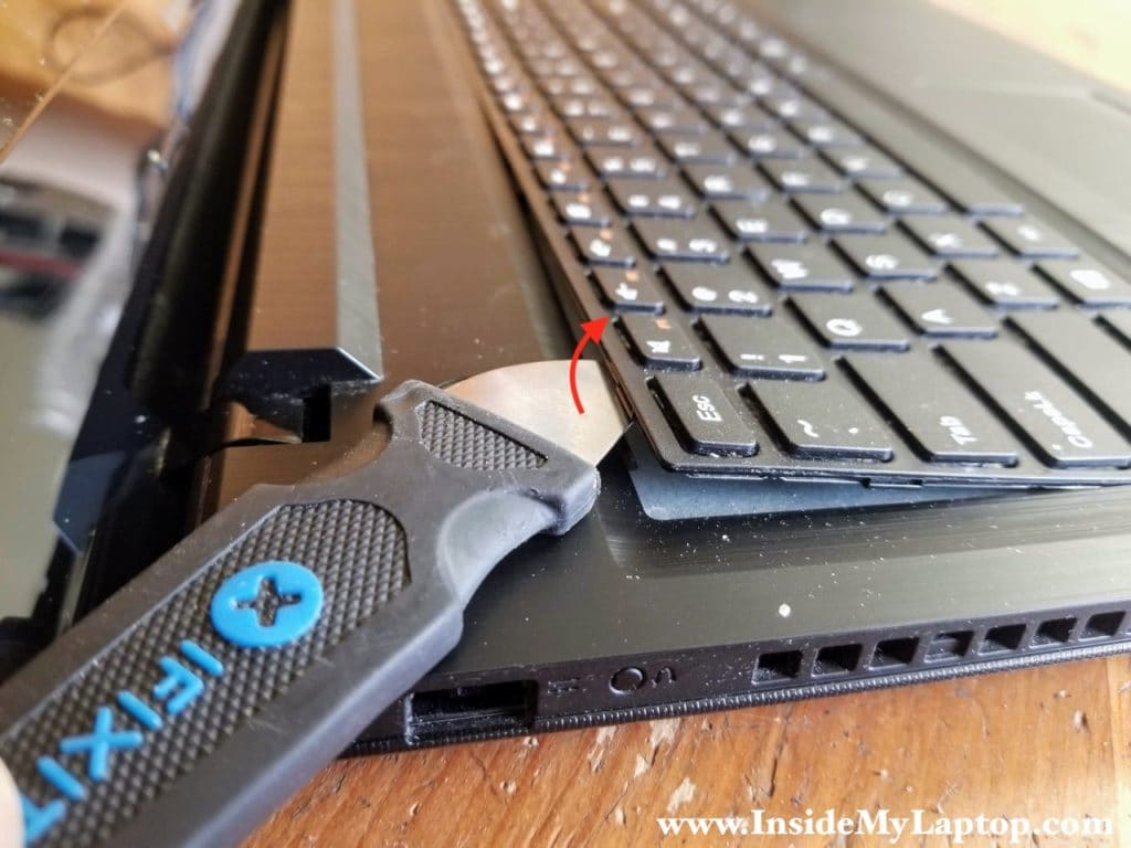 Using a thin case opener tool start separating the keyboard from the palmrest.