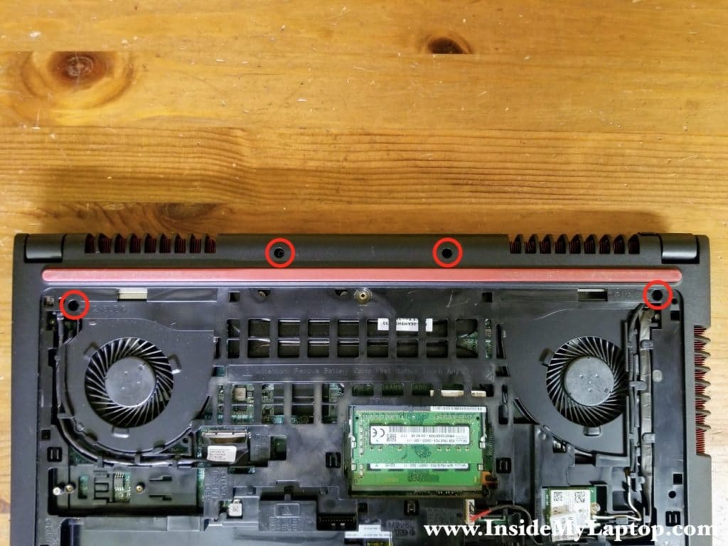 Remove four screws securing the palmrest assembly on the bottom of the laptop.