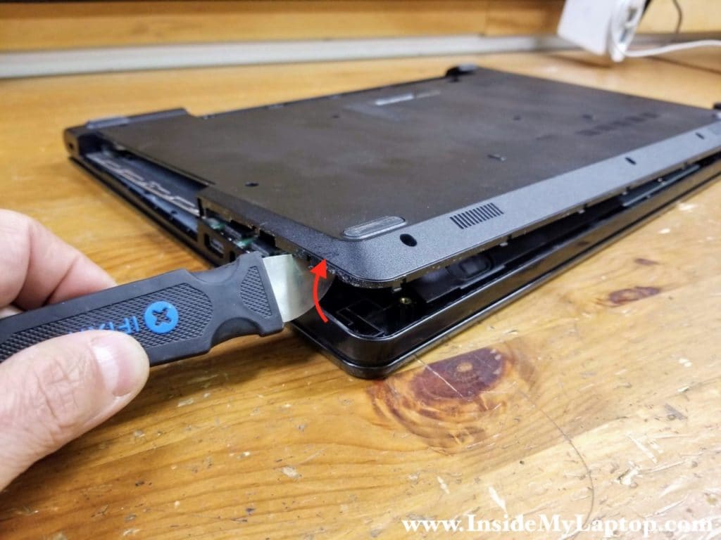 Start separating the base cover from the top case with the case opening tool.