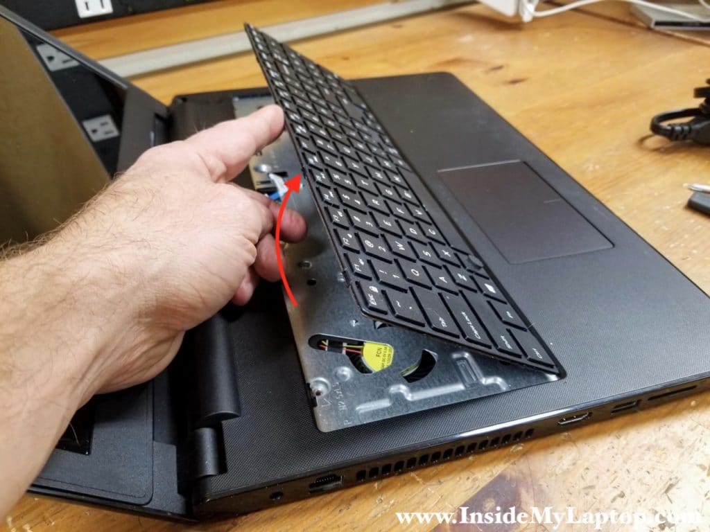 Continue removing the keyboard with your hands and place it upside down on the palmrest.