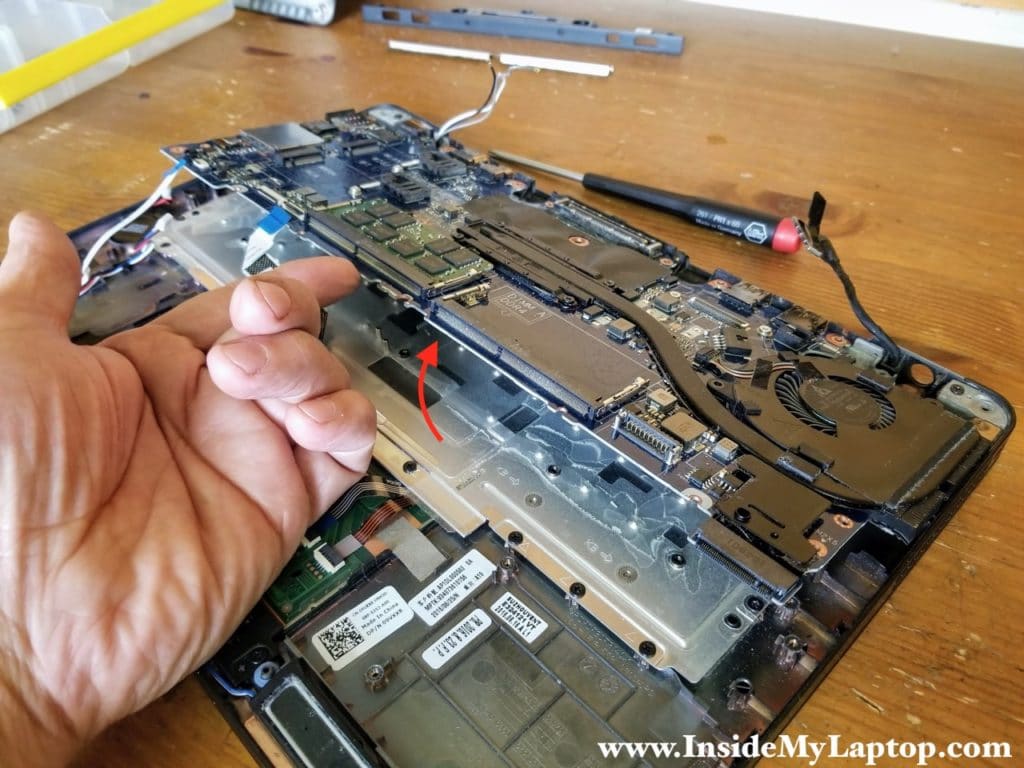 Lift up one side of the motherboard and pull it towards the touchpad to separate from the top case assembly.