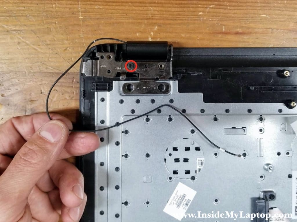 Remove one screw from the other display hinge. Un-route the Wi-Fi antenna cable from the guided path on the top case.