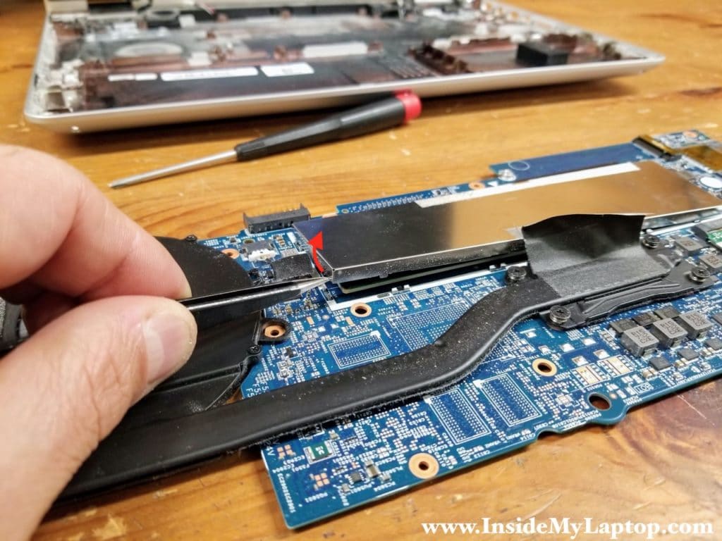 Start separating the memory cover from the motherboard. The cover is secured by a few clamps located on the motherboard.