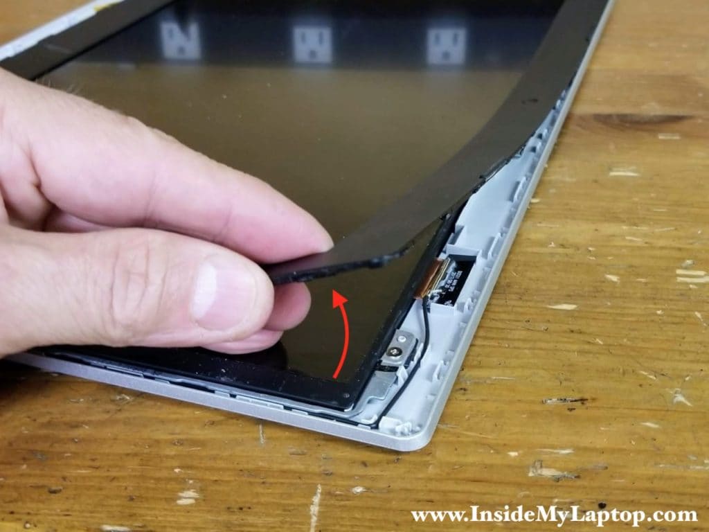 Start separating the front bezel from the display back cover.