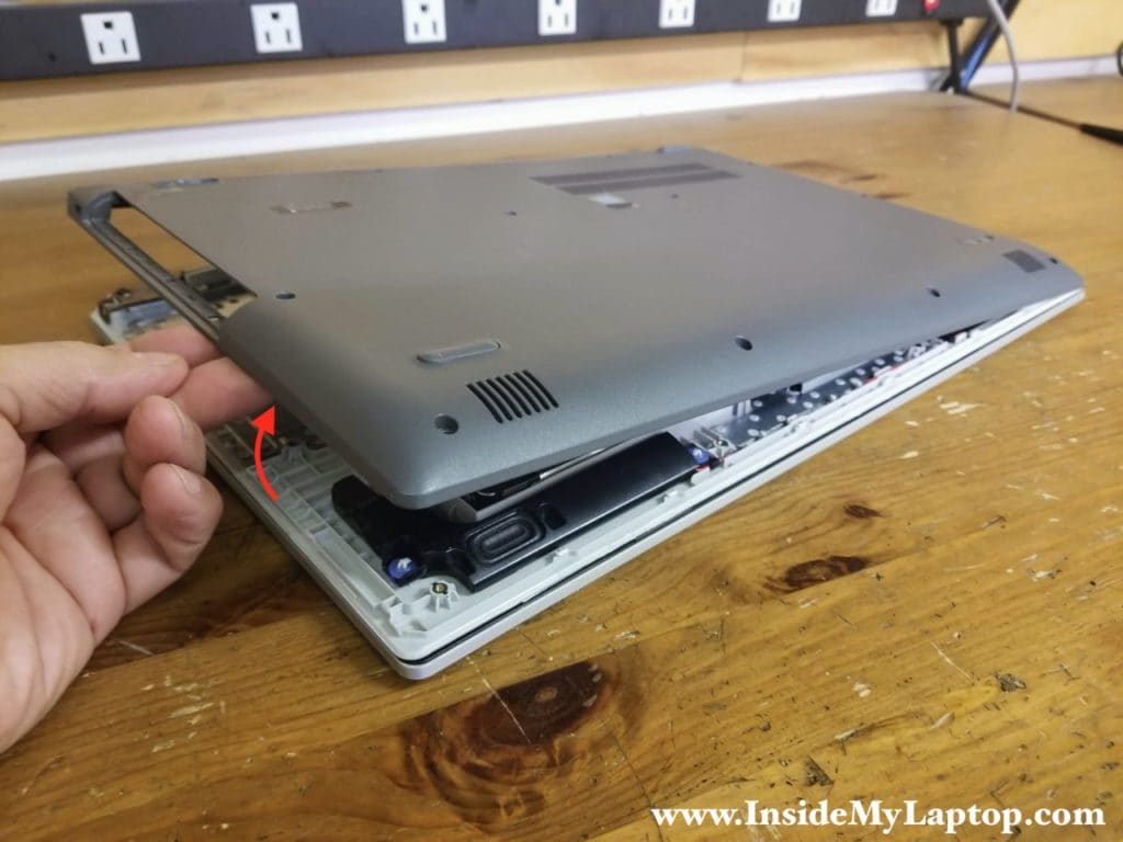 Turn the laptop upside down and continue removing the base cover with your fingers.