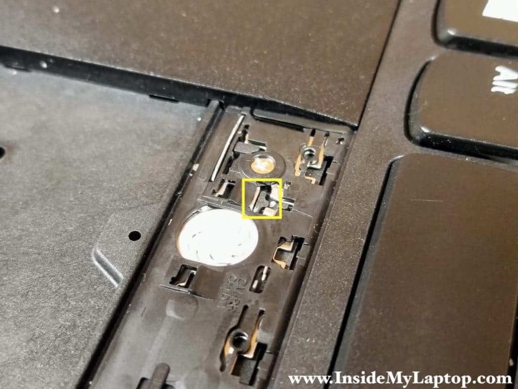 There is a T-shaped knob (shown inside the yellow square) securing the keyboard.