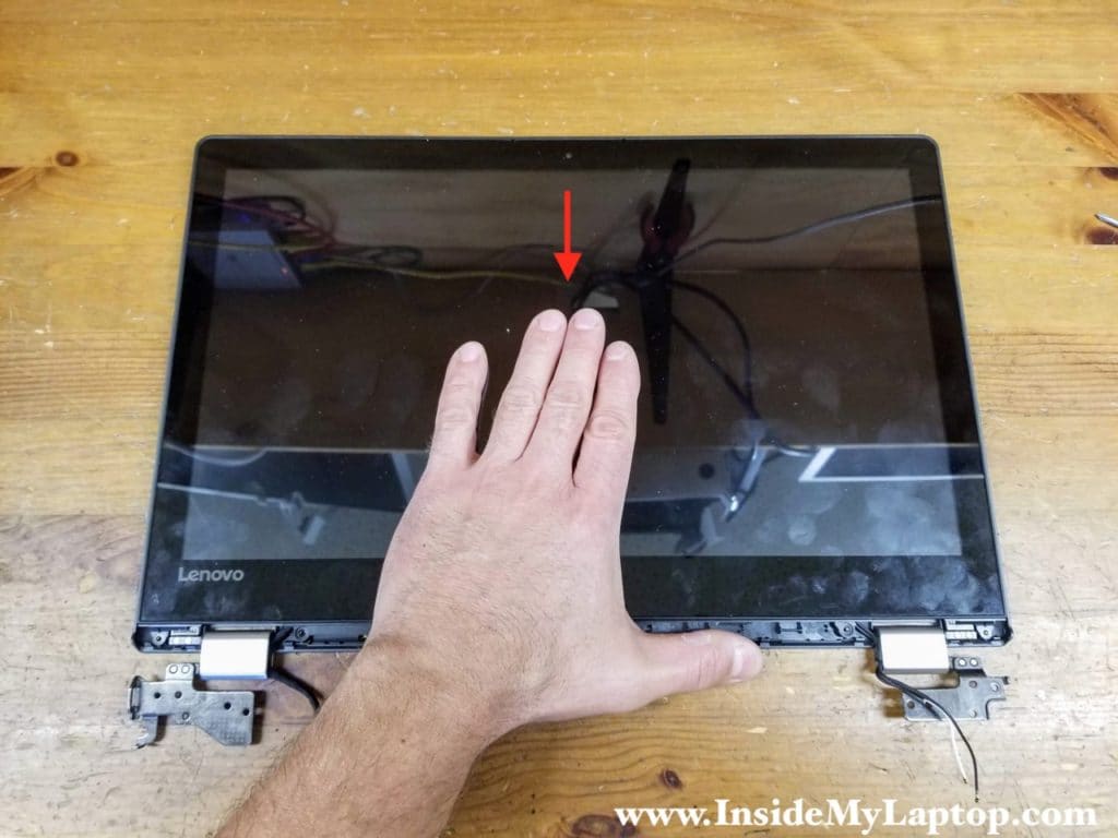 Slide the touchscreen towards the hinges.