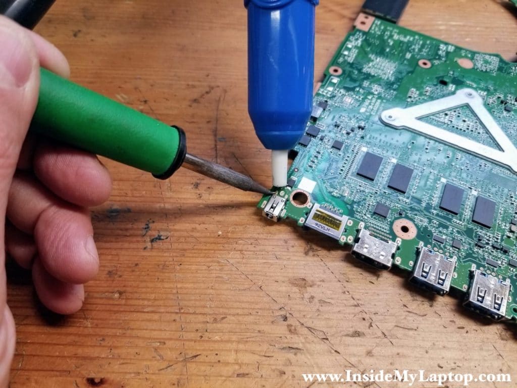 Removing old solder with desoldering pump.