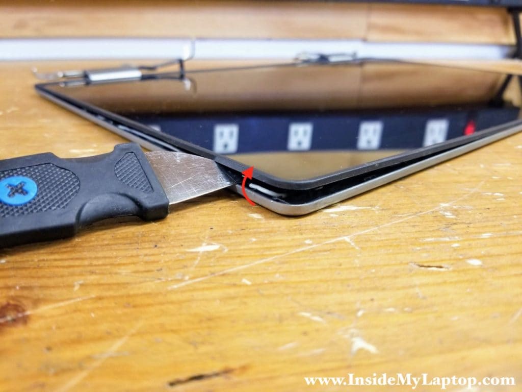 Start separating the touchscreen assembly from the display back cover using a thin case opener tool.