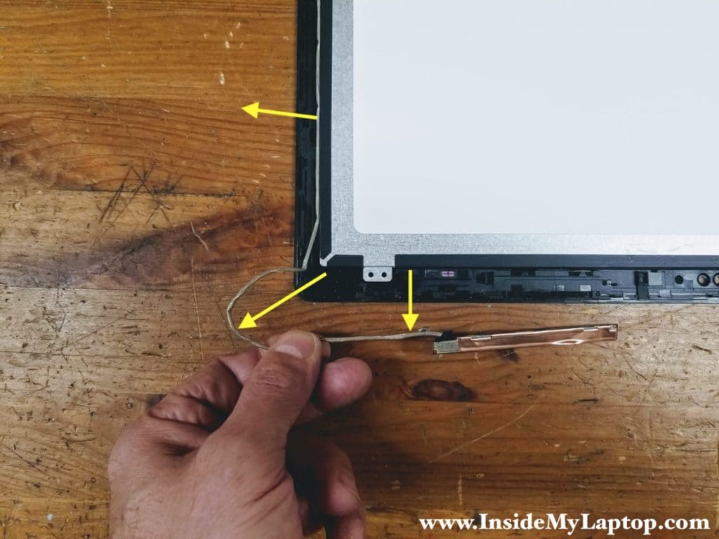 Un-route the webcam cable from the guided path on the left side of the touchscreen assembly.