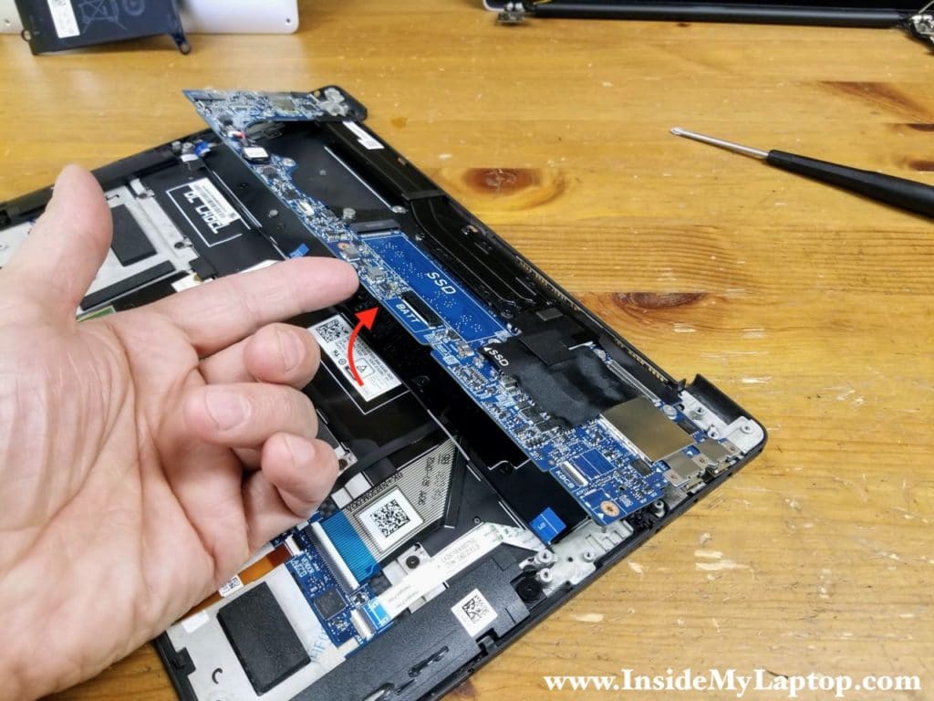 Start removing the motherboard from the top case assembly.